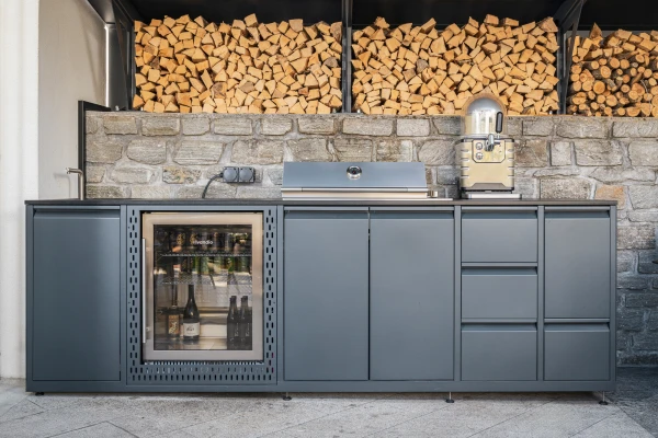 Massgeschneiderte Outdoorküche mit integriertem Getränkekühlschrank und viel Stauraum.