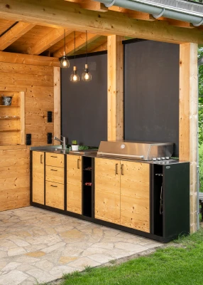 Individuelle Outdoor-Küche aus Holz, Stahl und Edelstahl unter einem gedeckten Sitzplatz.